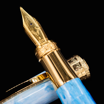 Macro shot of Visconti Comedia Paradiso fountain pen gold nib and detailed section ring.