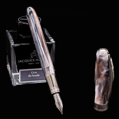 Visconti Comedia Purgatorio fountain pen uncapped with Jacques Herbin Gris de Houle ink bottle on black background