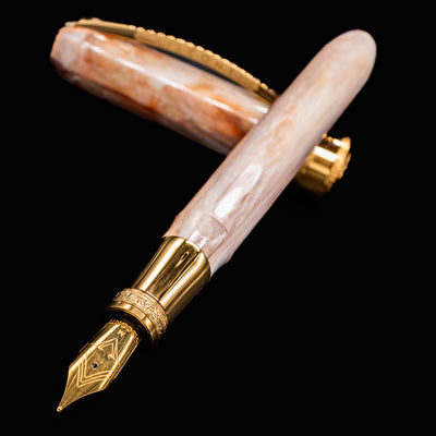 Flat lay of uncapped Visconti Comedia Virgilio Fountain Pen with gold nib