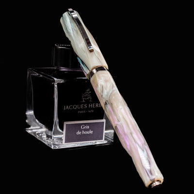 Visconti Divina Abalone Serial #1 Fountain Pen resting on Jacques Herbin ink bottle