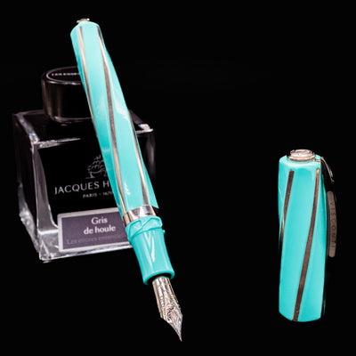 Uncapped Visconti Divina Elegance Wave Fountain Pen beside ink bottle with nib exposed