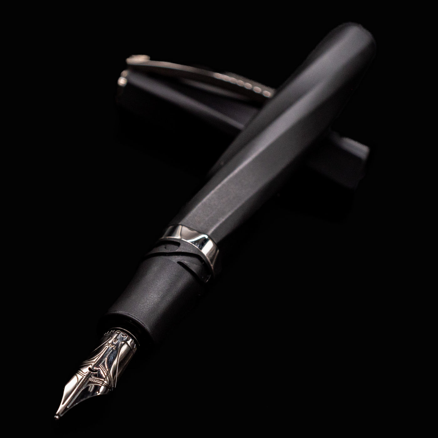 Angled close-up of Visconti Divina Matte Black Fountain Pen showing silver nib and faceted barrel
