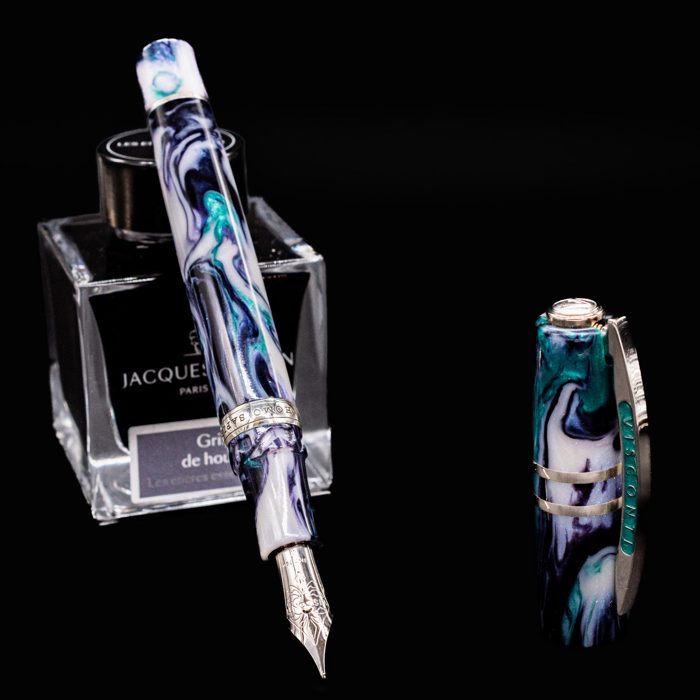 Visconti Homo Sapiens Earth Origins Air fountain pen with nib exposed, leaning on Jacques Herbin ink bottle