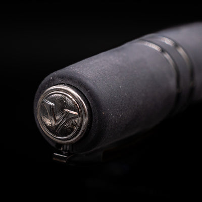 Close-up of a black Visconti Homo Sapiens pen with a metallic logo on a black background