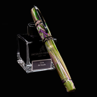 Visconti Homo Sapiens Lotus Garden Fountain Pen resting on Jacques Herbin Gris de Houle ink bottle