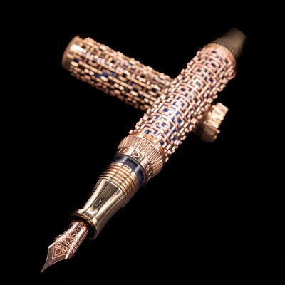 Full-length uncapped Visconti Looking East Fountain Pen showcasing intricate rose gold pattern over deep blue resin