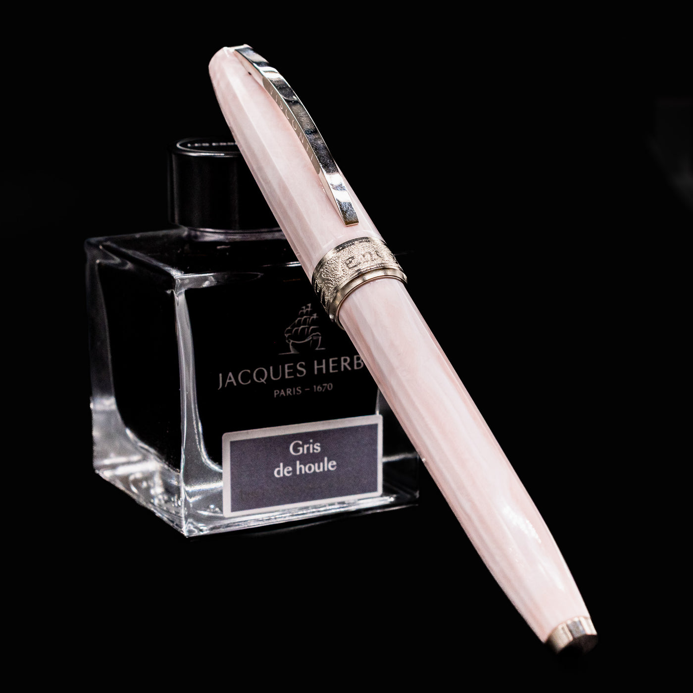 Visconti Michelangelo Venus Rose Fountain Pen resting on Jacques Herbin Gris de Houle ink bottle