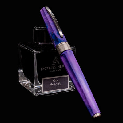 Visconti Mirage Mythos Fountain Pen in Persephone fully capped and resting on Jacques Herbin Gris de Houle ink bottle