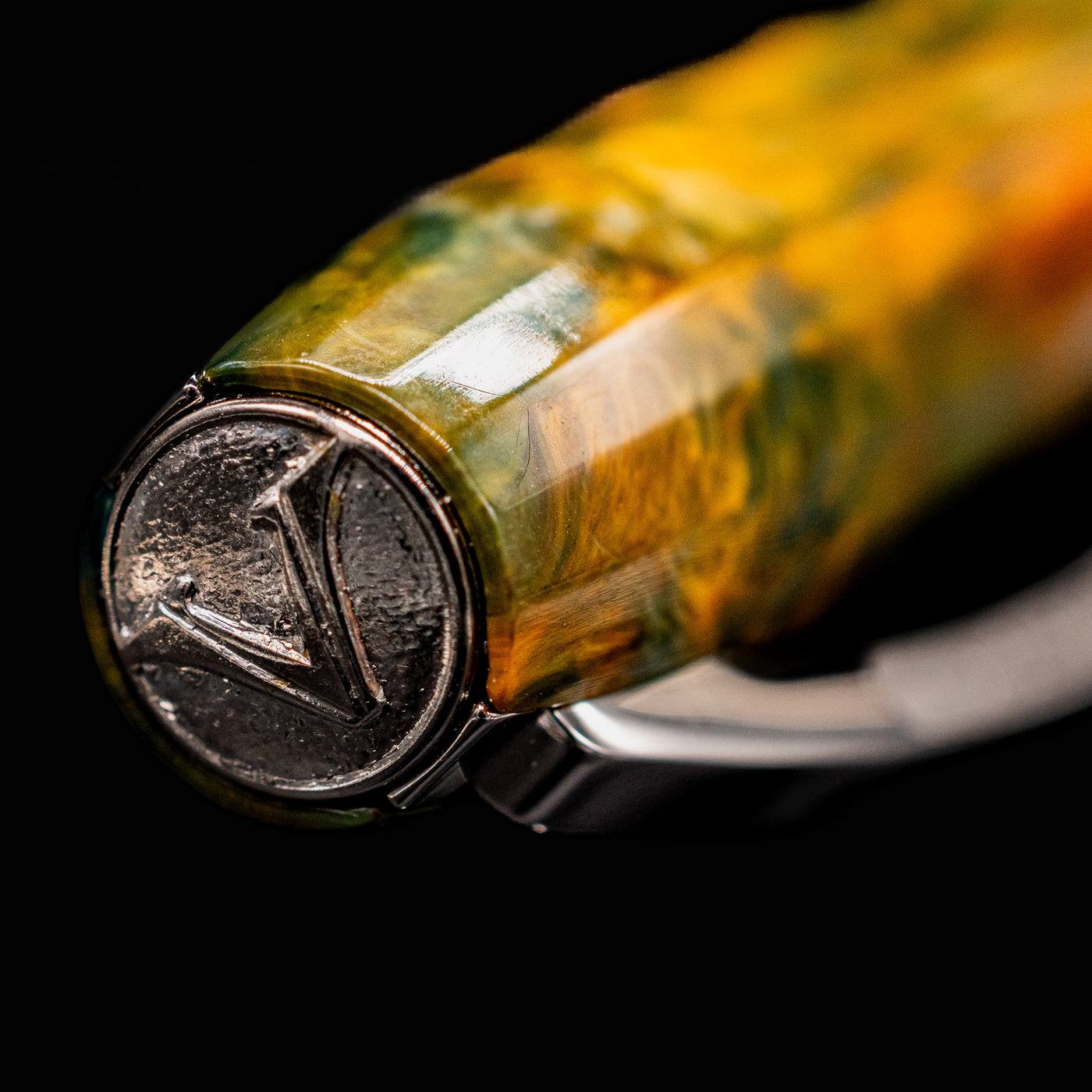 Close-up of Visconti Van Gogh Café Terrace fountain pen cap showing silver V emblem on finial