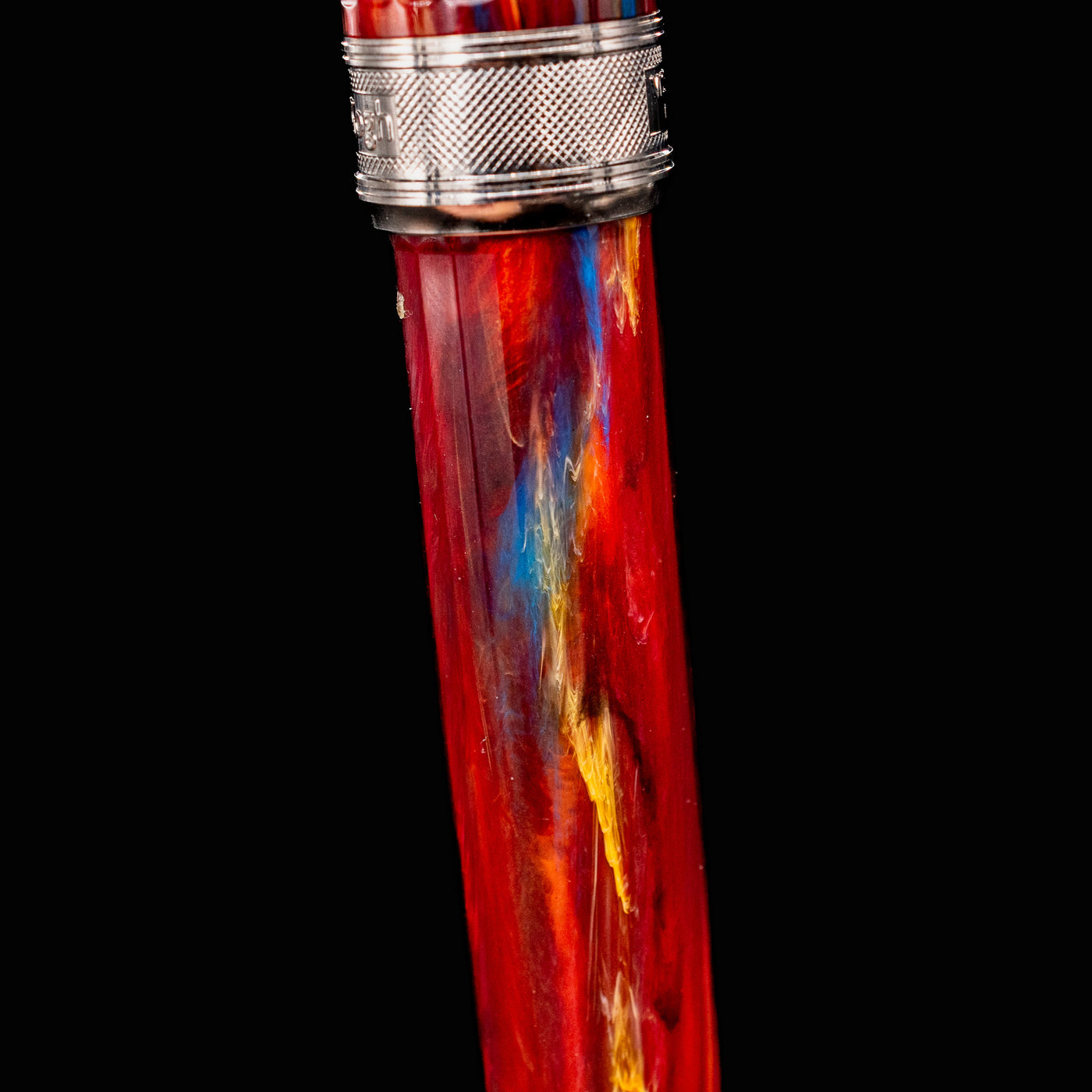 Detail view of Visconti Van Gogh Red Vineyard Fountain Pen resin barrel showing swirling red, blue, and yellow marbled acrylic