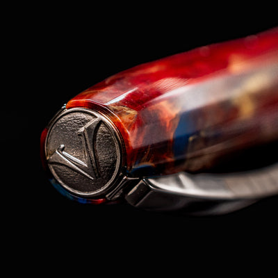 Close-up of Visconti Van Gogh Red Vineyard Fountain Pen cap medallion with engraved V logo and colorful resin detail