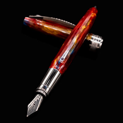 Close-up of Visconti Van Gogh Red Vineyard Fountain Pen nib with cap crossed over, highlighting swirling red and gold marbled resin