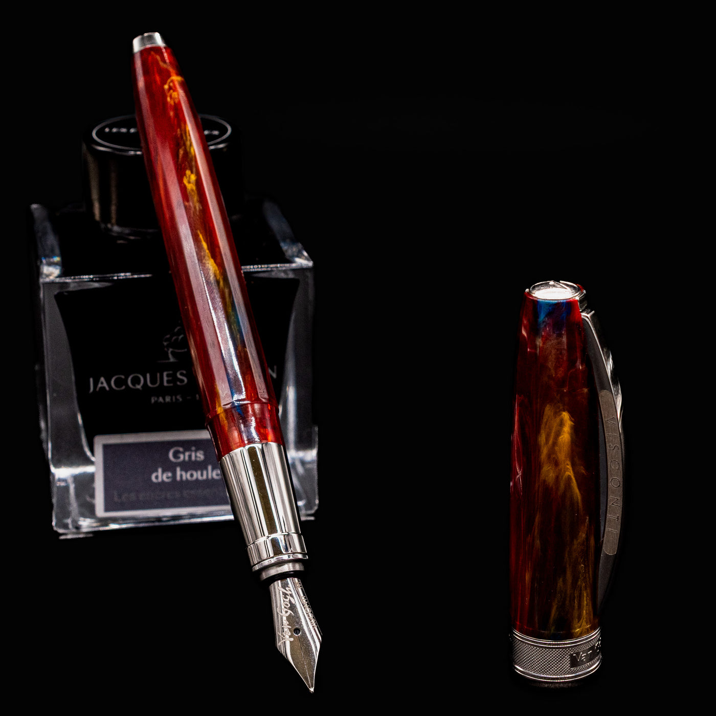 Uncapped Visconti Van Gogh Red Vineyard Fountain Pen beside cap and ink bottle, showcasing polished nib and vibrant resin body
