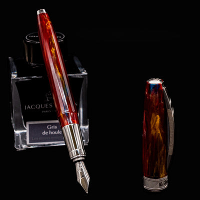 Uncapped Visconti Van Gogh Red Vineyard Fountain Pen beside cap and ink bottle, showcasing polished nib and vibrant resin body