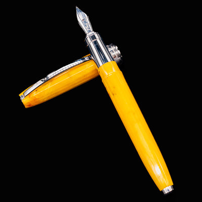 Visconti Van Gogh Sunflowers Fountain Pen posed with cap beside pen body on black background