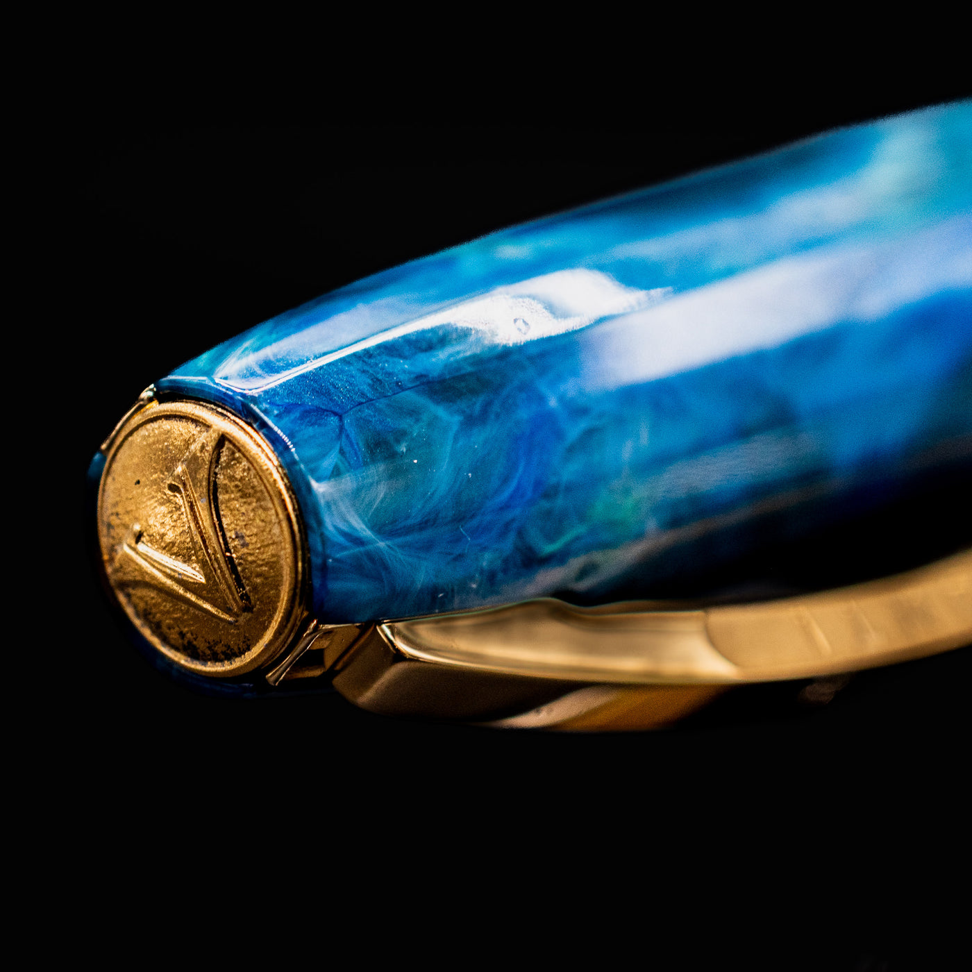 Close-up of Visconti Van Gogh Wheatfield with Crows fountain pen cap finial showing raised Visconti logo.