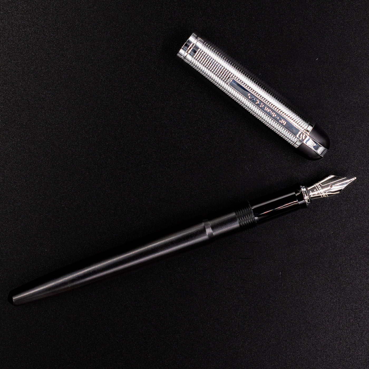 Wahl Eversharp Skyline Fountain Pen - Black & Chrome shown uncapped with cap laid beside the pen on a black background.