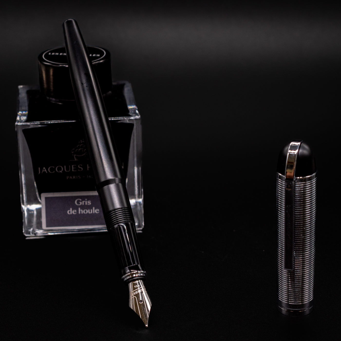 Wahl Eversharp Skyline Fountain Pen - Black & Chrome uncapped and placed near Jacques Herbin Gris de Houle ink bottle.