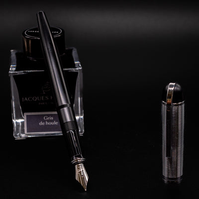 Wahl Eversharp Skyline Fountain Pen - Black & Chrome uncapped and placed near Jacques Herbin Gris de Houle ink bottle.