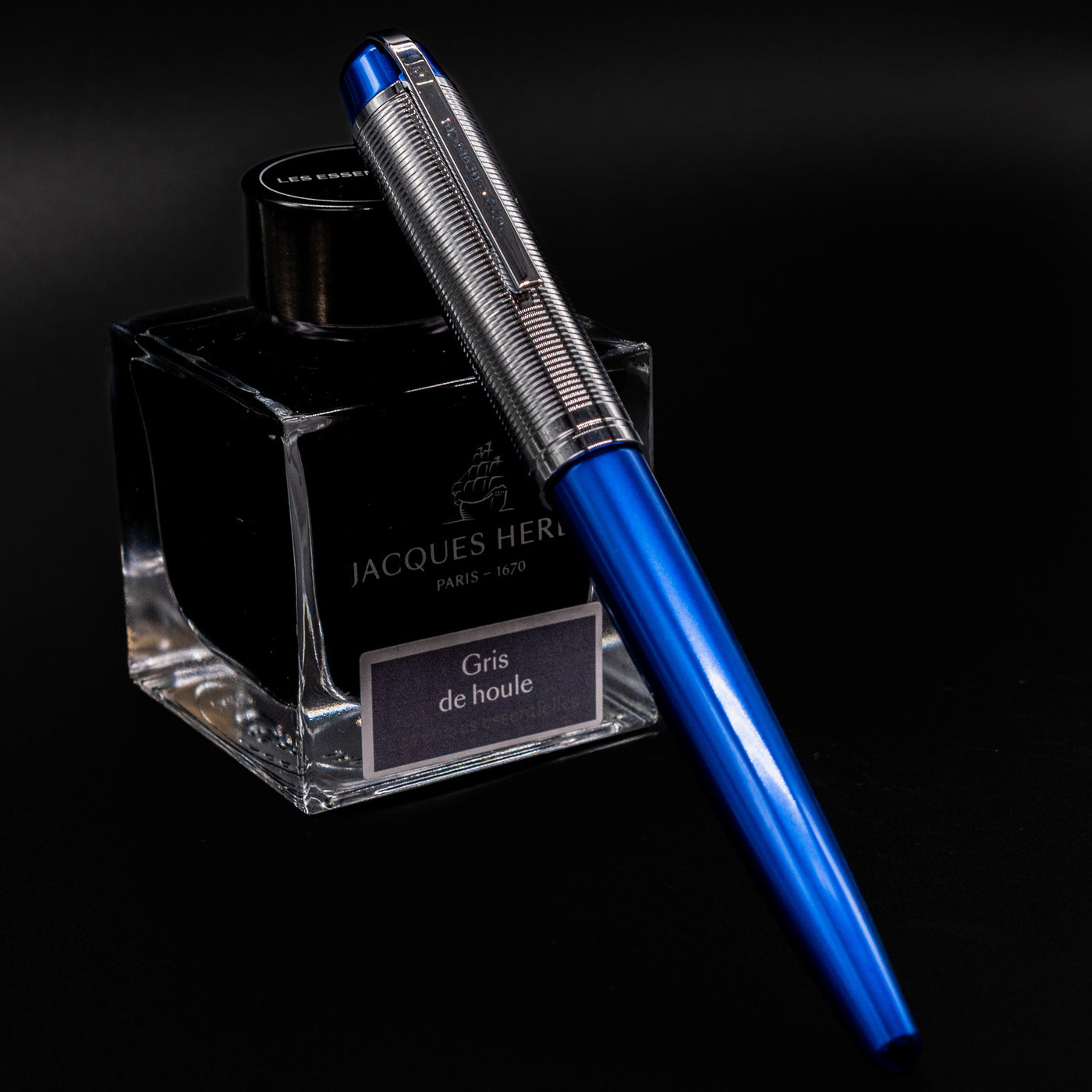 Wahl Eversharp Skyline Fountain Pen - Blue & Chrome resting capped on Jacques Herbin Gris de Houle ink bottle.