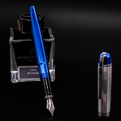 Wahl Eversharp Skyline Fountain Pen - Blue & Chrome placed uncapped next to Jacques Herbin ink bottle.