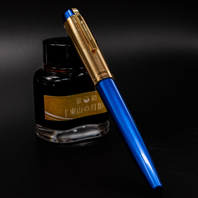 Wahl Eversharp Skyline Fountain Pen - Blue & Gold capped and resting against a bottle of fountain pen ink.
