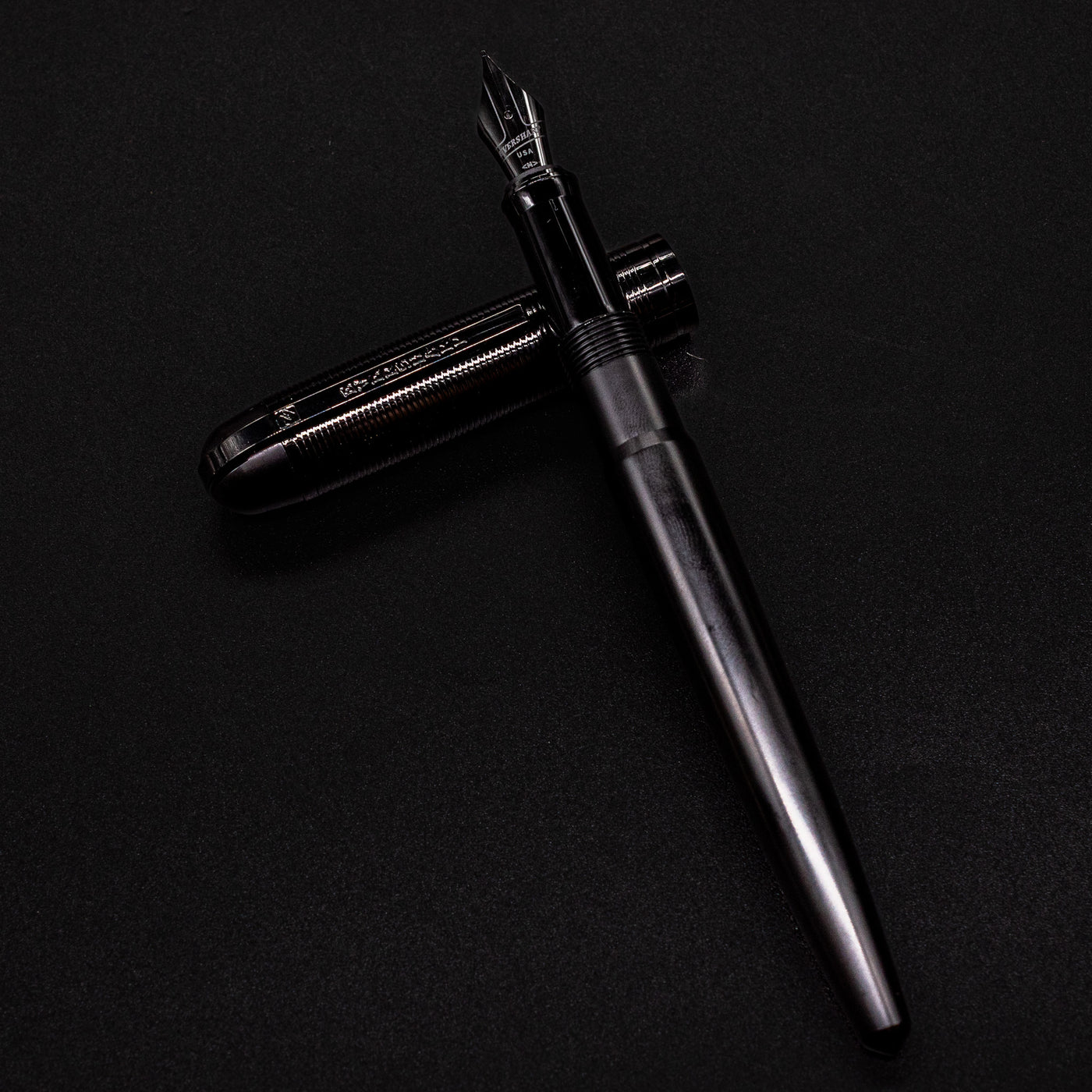 Full view of the uncapped Wahl Eversharp Skyline Fountain Pen - Aviator Black laid flat with cap beside it.