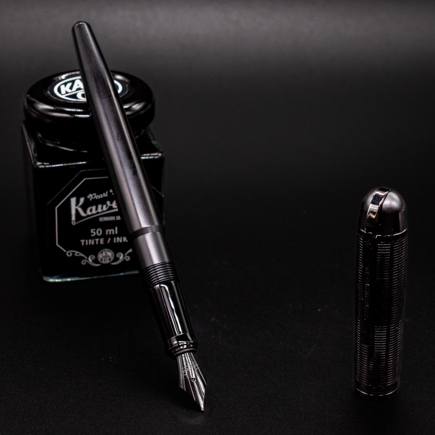 Wahl Eversharp Skyline Fountain Pen - Aviator Black posed with Kaweco Pearl Black ink bottle in a writing setup.