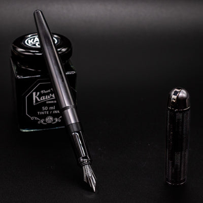 Wahl Eversharp Skyline Fountain Pen - Aviator Black posed with Kaweco Pearl Black ink bottle in a writing setup.
