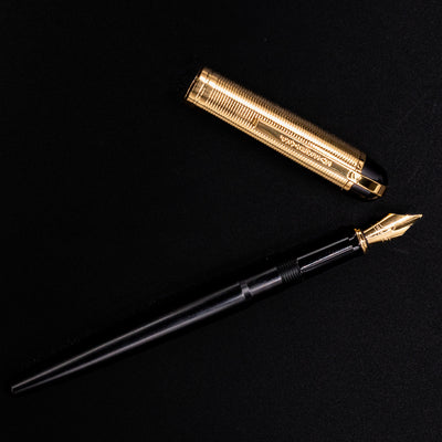 Uncapped Wahl Eversharp Skyline Fountain Pen - Black & Gold with gold nib and cap placed above