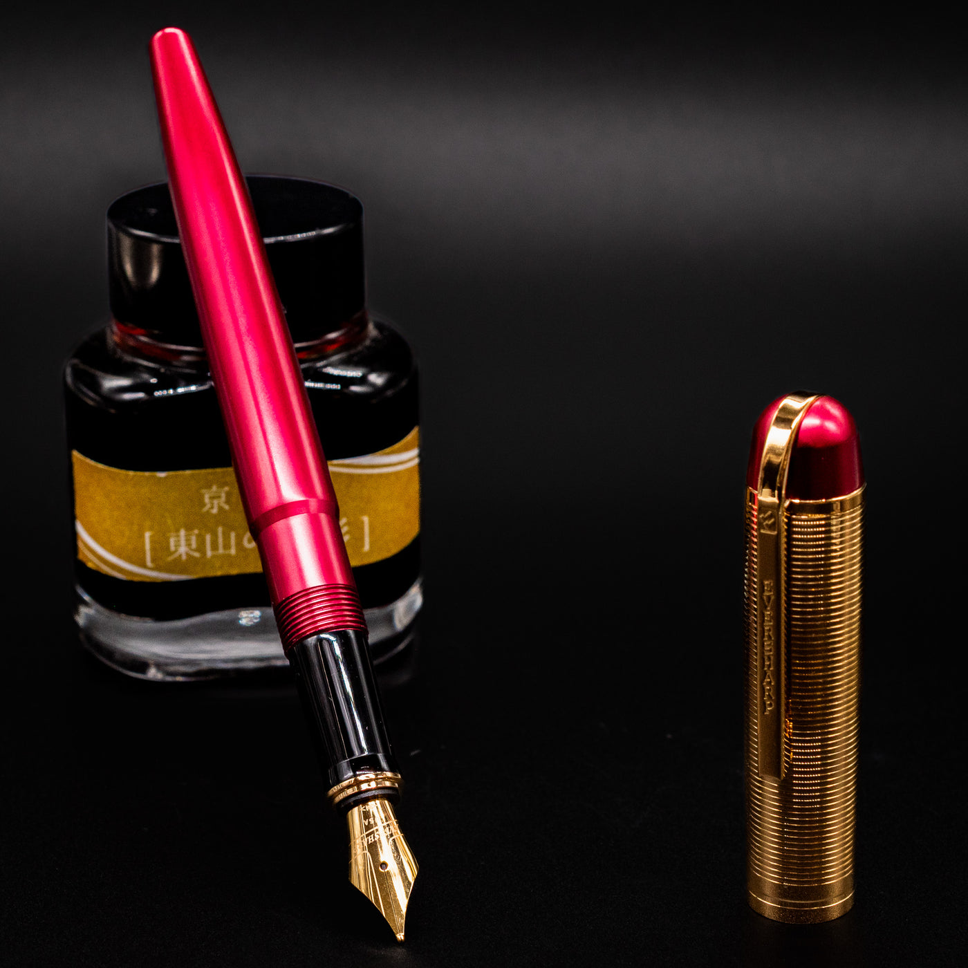 Wahl Eversharp Skyline Fountain Pen - Red & Gold shown uncapped next to a bottle of ink.