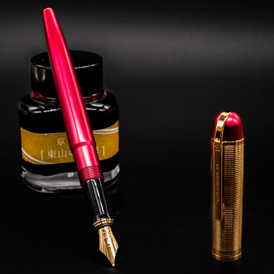 Wahl Eversharp Skyline Fountain Pen - Red & Gold shown uncapped next to a bottle of ink.