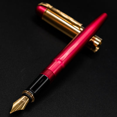 Angled photo of the uncapped Wahl Eversharp Skyline Red & Gold Fountain Pen showing nib and section.